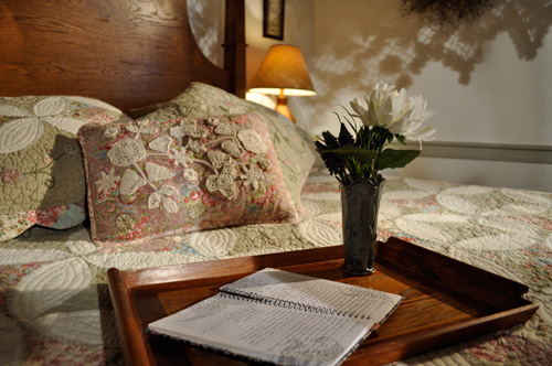 Needlework and quilted pillows adorn bed at the historic Jean Bonnet Tavern, Bedford, PA