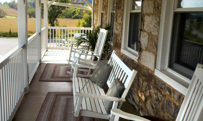 Comfy porch with swing and rocking chairs on upper balcony at the Jean Bonnet Tavern B&B